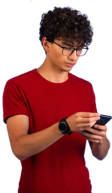 Young man with glasses looks intently at his phone; wearing a red shirt.